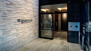 Das Daiwa Roynet Hotel mit moderner Gestaltung, mit einer Steinfassade und einem Glasanbau.