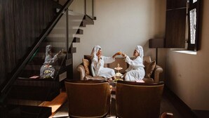 A modern interior with a staircase, leather chairs, and a dining table. - Hotel Monte Pacis (Kaunas)