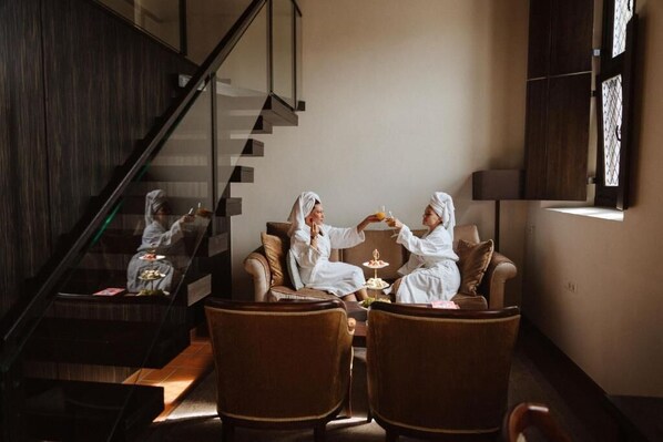 Um interior moderno com escada, poltronas de couro e uma mesa de jantar.