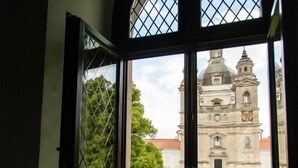Ein Fenster mit Blick auf ein historisches Gebäude mit Kuppel und Glockenturm.