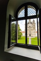 Een raam met uitzicht op een historisch gebouw met een koepel en klokkentoren.