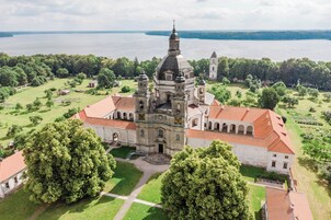 Una iglesia grande con un campanario destacado y un jardín circundante.