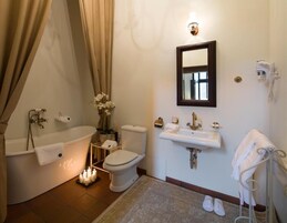 A bathroom with a bathtub, toilet, sink, and a mirror.