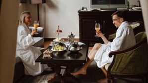 Ein Zimmer mit Esstisch für zwei Personen, einem Fernseher auf einem Schrank und einer Lampe.