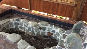 A stone hot tub with a wooden deck surrounding it. - VILLA Kano (Okinawa)