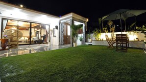 A well-lit outdoor area with a patio, seating, and a covered area. - VILLA Kano (Okinawa)