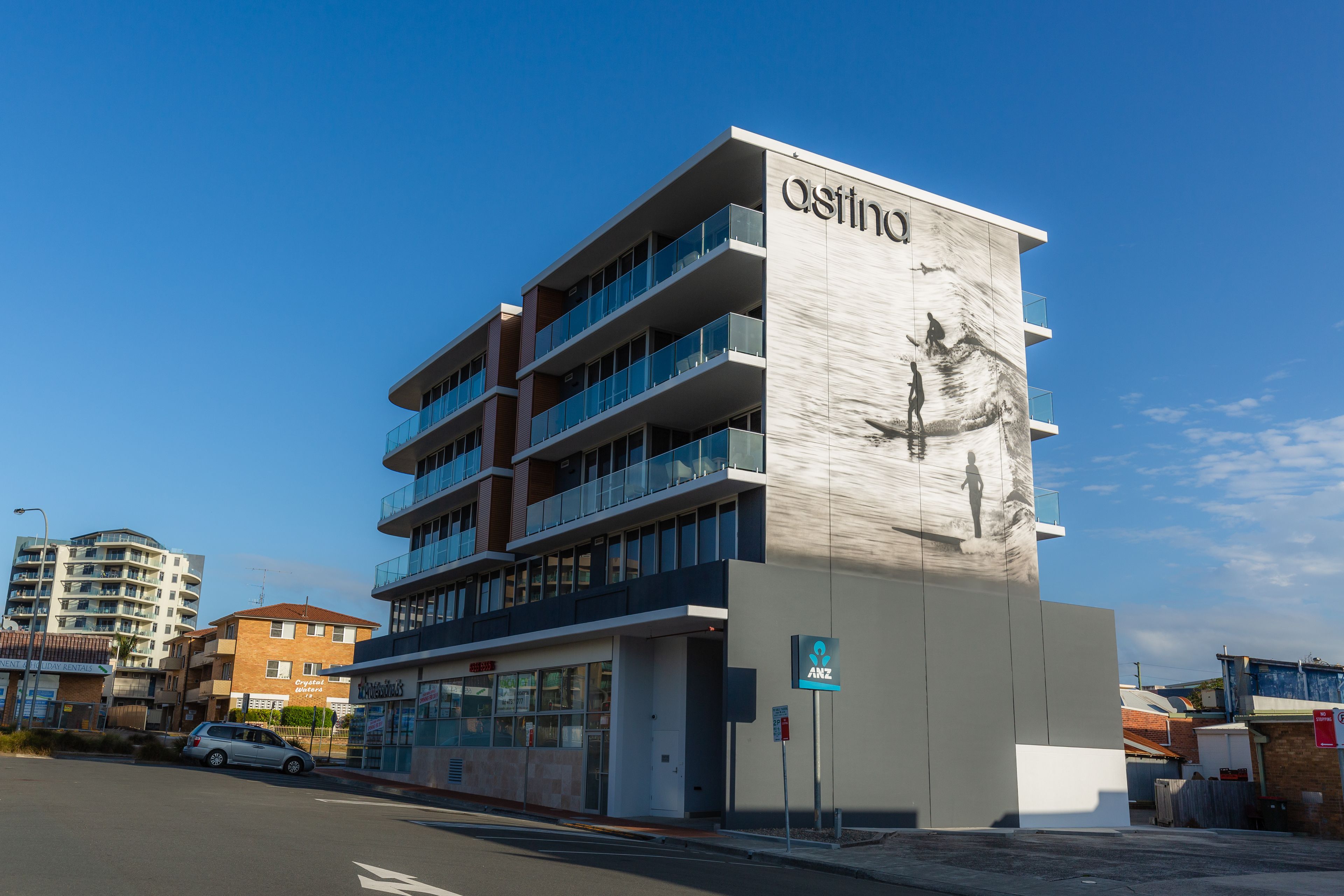 Un edificio moderno con balconi e un grande cartello con scritto 'astino'.
