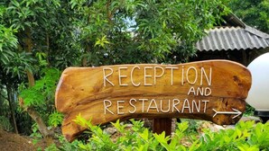 A wooden sign with the words "RECEPTION AND RESTAURANT" indicating the location of the reception and dining area. - Mai Chau Xanh Bungalow (Mai Ha)