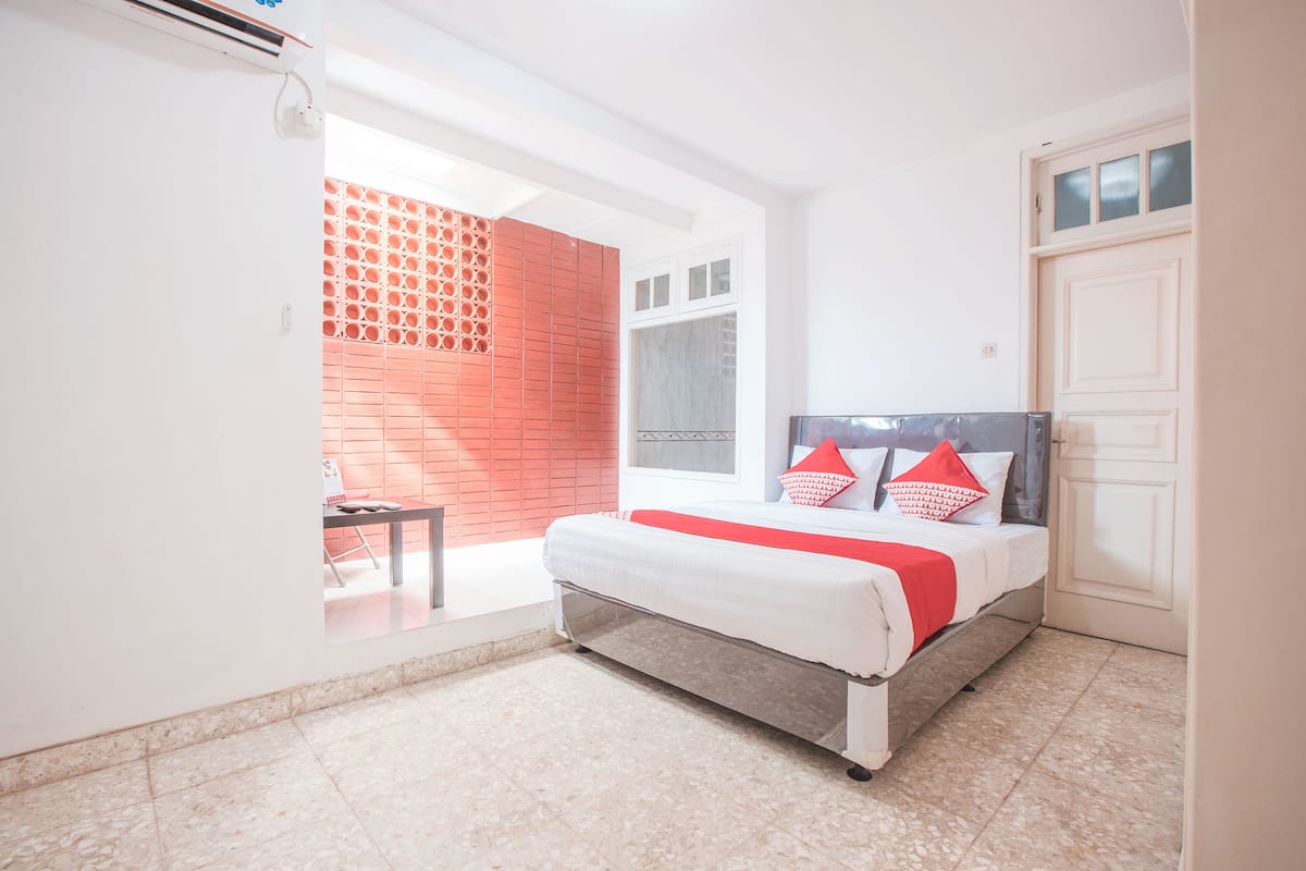 Une chambre à coucher avec un lit, une petite table et un mur en briques rouges.