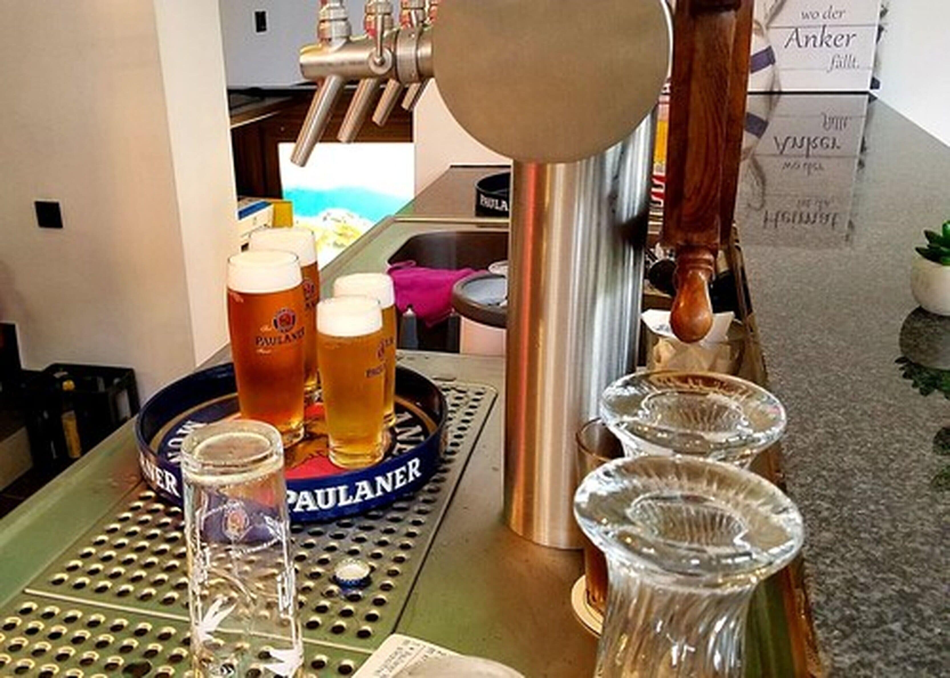 Eine Barbereich mit Zapfhähnen, Gläsern und einem Tablett mit einer Bierflasche.