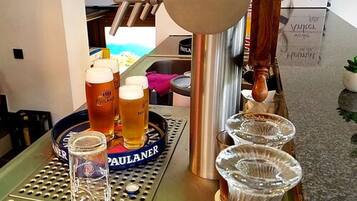 Eine Barbereich mit Zapfhähnen, Gläsern und einem Tablett mit einer Bierflasche.