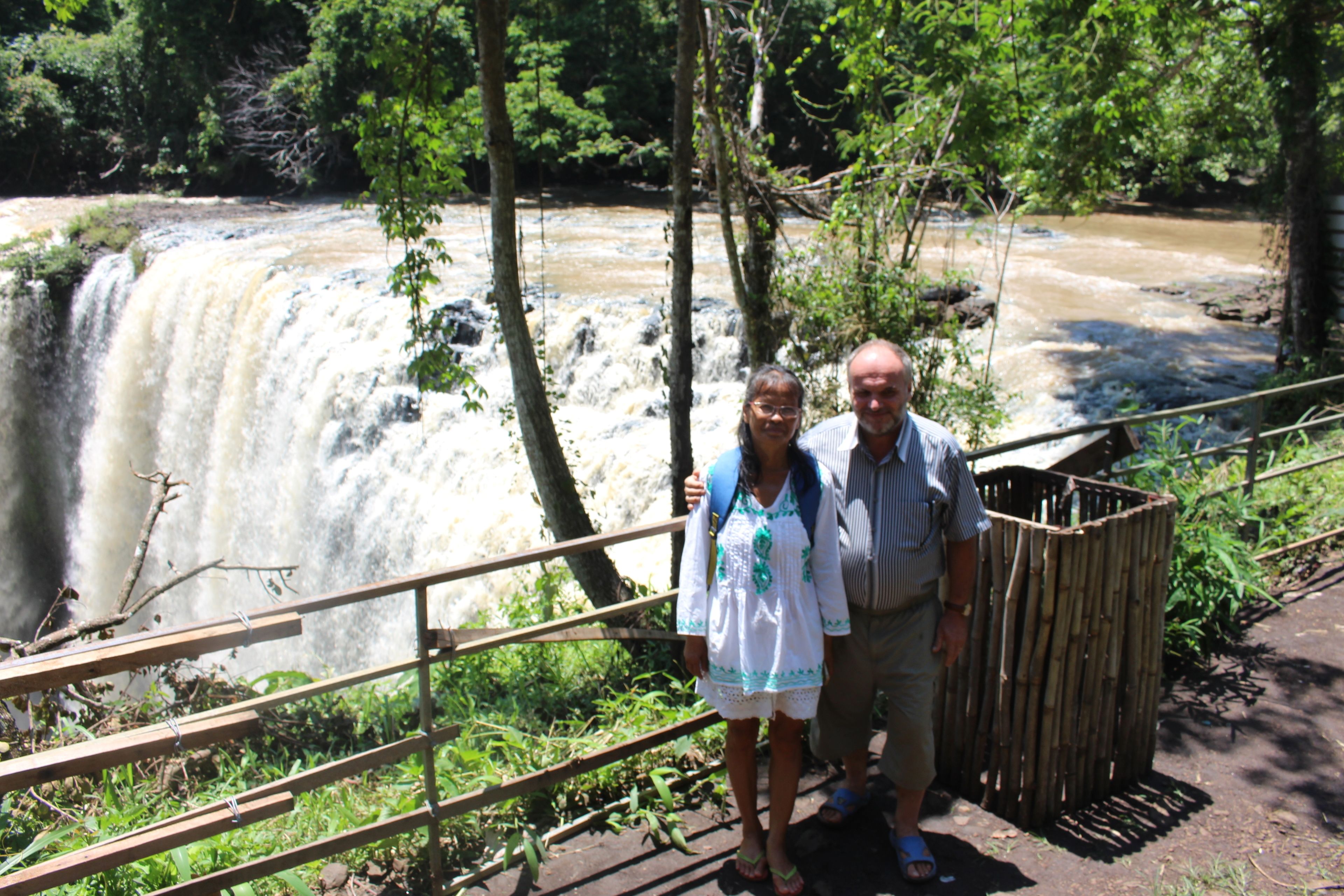 A wooden staircase leading to a viewpoint overlooking a waterfall.