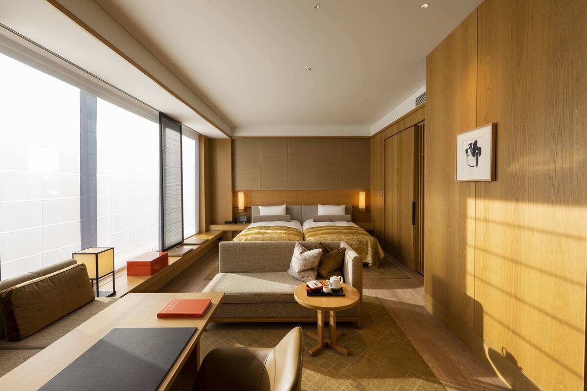 Ett modernt hotellrum med en stor säng, en soffa, ett litet bord och ett skrivbord.