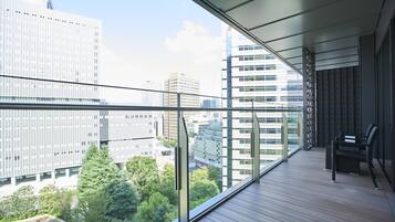A balcony with a view of city buildings and greenery.