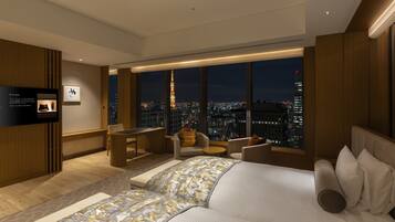 Una habitación de hotel moderna con vistas a la ciudad, un escritorio y una zona de estar confortable.