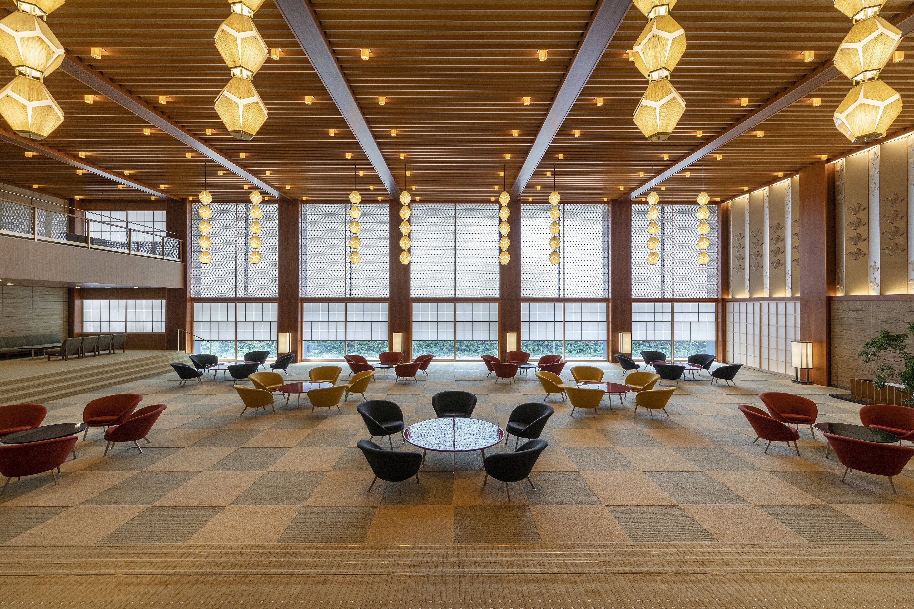 A spacious lobby with a checkered floor, multiple seating areas, and large windows offering a view.