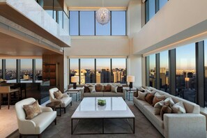 A spacious living area with a city view, a chandelier, and a modern design. - The Okura Tokyo (Tokyo)