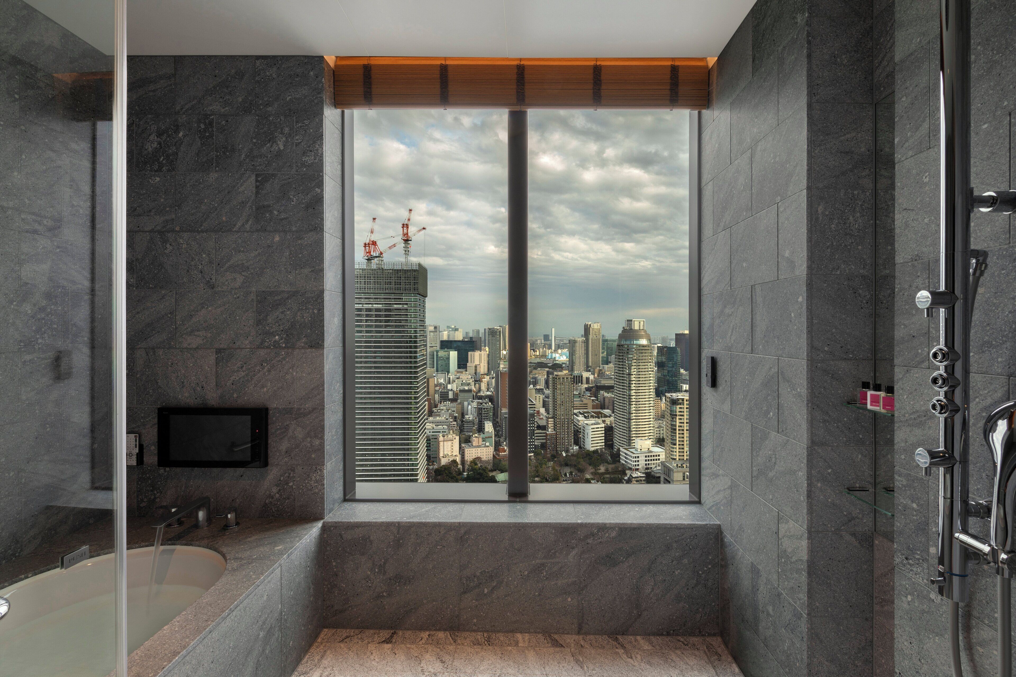 Un baño moderno con un ventanal grande, una bañera y zona de ducha.