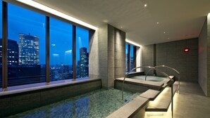 A modern indoor pool with a city view, clear water, and a minimalist design. - The Okura Tokyo (Tokyo)