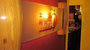 Un letrero que dice 'The Roof Top Restaurant', con un logotipo que muestra un sol estilizado y un barco.