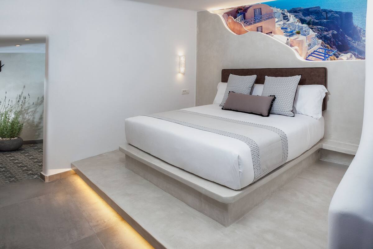Un dormitorio moderno con cama, mesita de noche y una lámpara de pared.