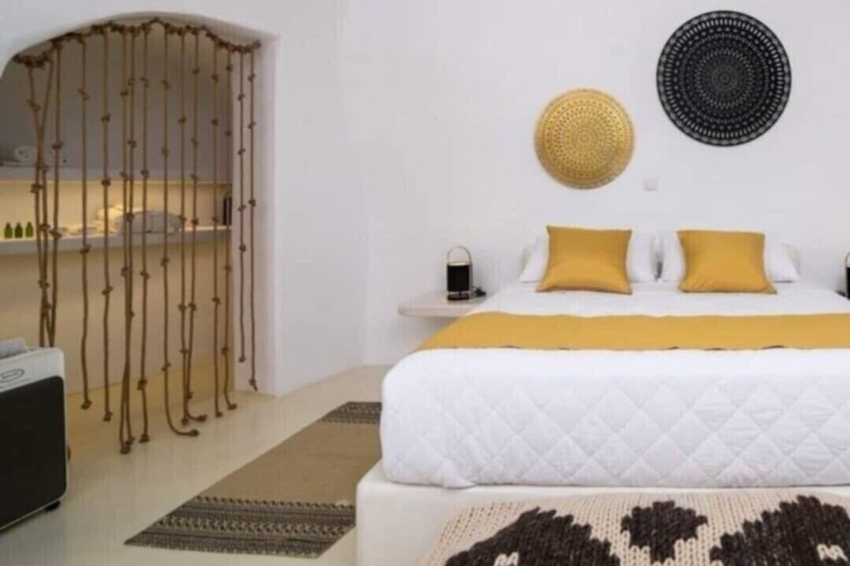Un dormitorio con cama, mesitas de noche, una lámpara colgante y un adorno circular en la pared.