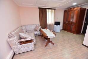 Suite, 1 King-Bett | Wohnbereich | Fernseher