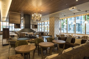 A modern cafe with wooden furniture, a chandelier, and large windows offering a view of the street. - Rembrandt Style Sapporo (Sapporo)