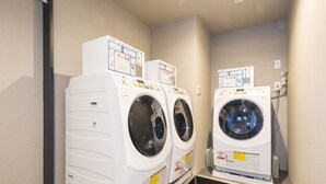 Une buanderie équipée de deux machines à laver à chargement frontal et d’un sèche-linge.