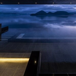 A spacious indoor area with a view of mountains through a glass wall. - The Lake Suite Ko No Sumika (Sobetsu)