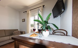 Departamento, 2 habitaciones, vista al jardín | Área de sala de estar | Televisión, estación para iPod y libros 