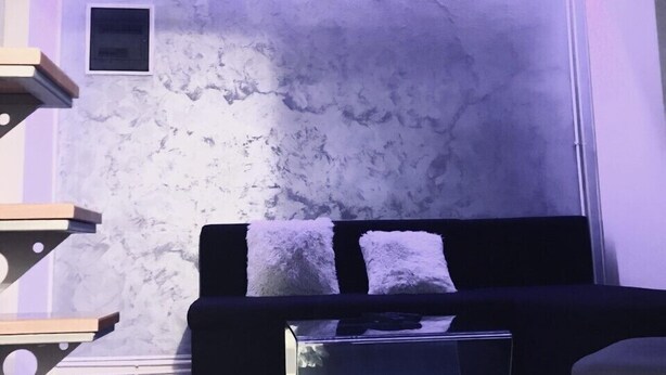 A modern living room with a black sofa, a glass coffee table, and a textured wall. - Beo-River Knez Mihajlova (Belgrade)