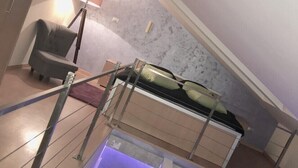A loft bedroom with a bunk bed, a chair, a lamp, and a view of the sky. - Beo-River Knez Mihajlova (Belgrade)