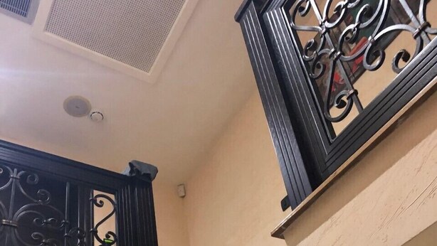 A staircase with ornate black metal railings and a beige wall. - Beo-River Chocolate (Belgrade)