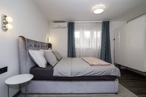 A modern bedroom with a bed, bedside tables, and a ceiling light fixture. - Beo-River White (Belgrade)