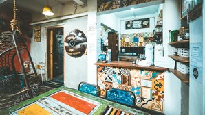 Un intérieur aux couleurs vives, avec un comptoir en bois, des carreaux décoratifs et une corde suspendue.