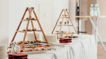 Montaje de bufé con mesas escalonadas, platos y diversos alimentos.