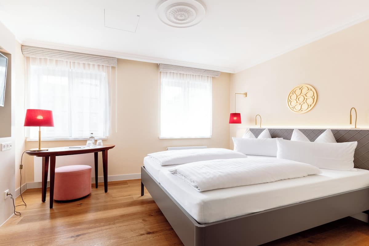 Una habitación de hotel moderna con una cama, un escritorio y una silla.