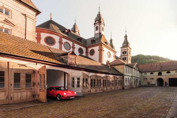 Un edificio histórico con un coche rojo estacionado al frente.