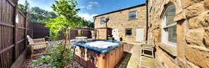 A stone building with a wooden deck, a hot tub, and a wooden fence. - Oakerthorpe Holiday Village (Alfreton)