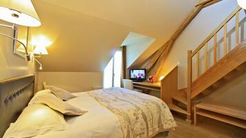 Ein Schlafzimmer mit einem Bett, einem Schreibtisch mit Computer und einer Holztreppe.