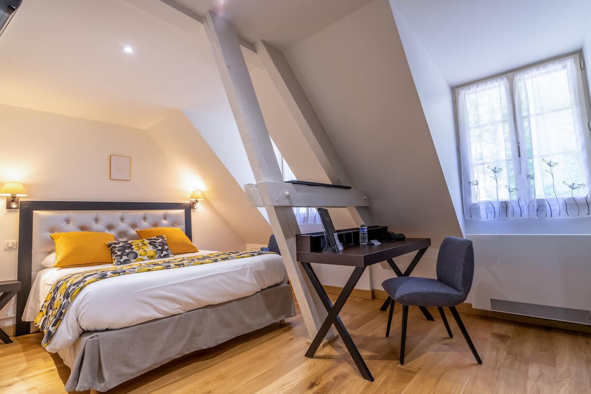Een slaapkamer met een bed, een bureau en een stoel.