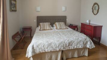 Un dormitorio con una cama grande, una mesita de noche, un aparador y un espejo en la pared.