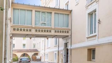 Una calle estrecha con un puente peatonal que conecta dos edificios.