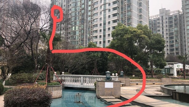 A swimming pool area with a bridge, surrounded by trees and high-rise buildings. - Pinkhostelling laternational (Shanghai)