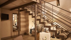 Un interior moderno con una escalera, un televisor de pantalla plana y una zona de estar acogedora.