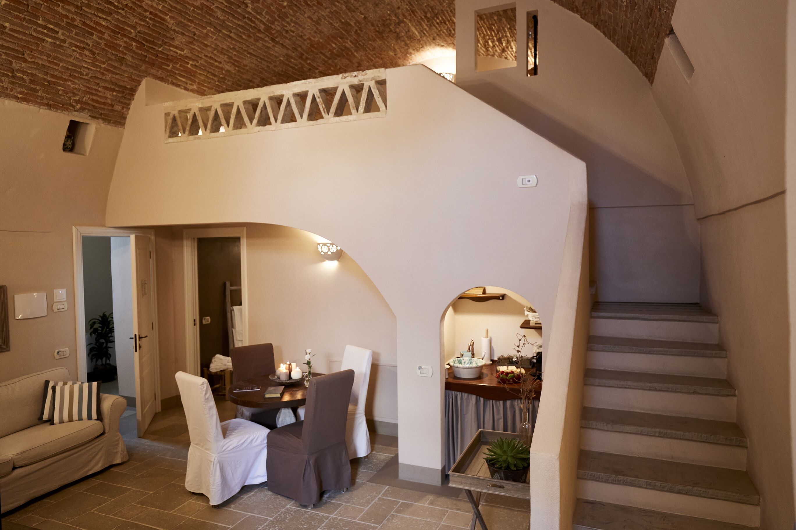 Un espacio de sala acogedor con una mesa de comedor, sillas y una escalera.