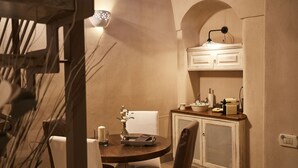 Un comedor acogedor con una mesa redonda, sillas y un armario con utensilios de cocina.