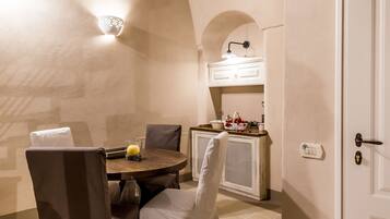 A dining area with a round table, chairs, and a wall-mounted light fixture.