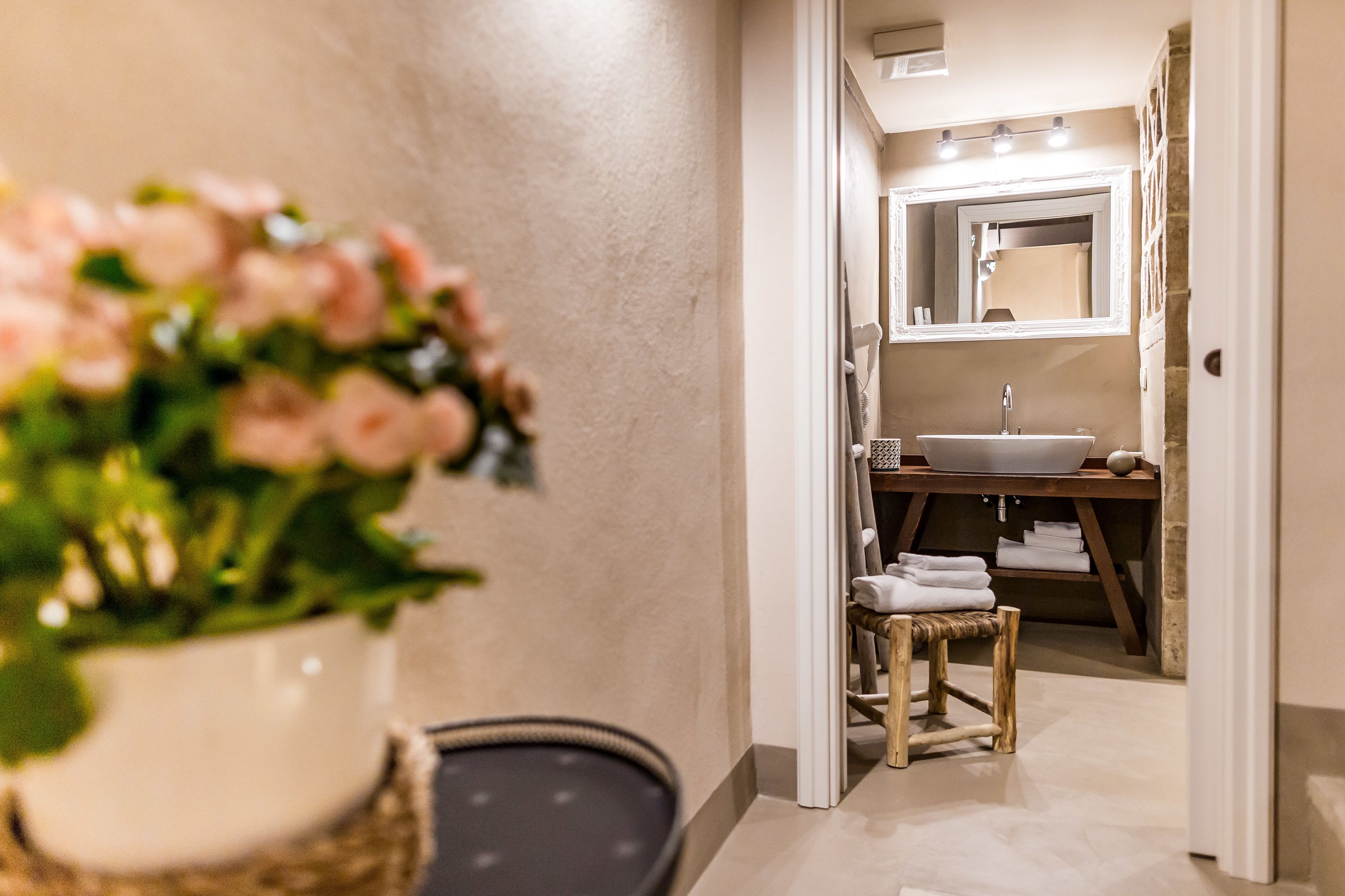 A bathroom with a sink, mirror, and towels.